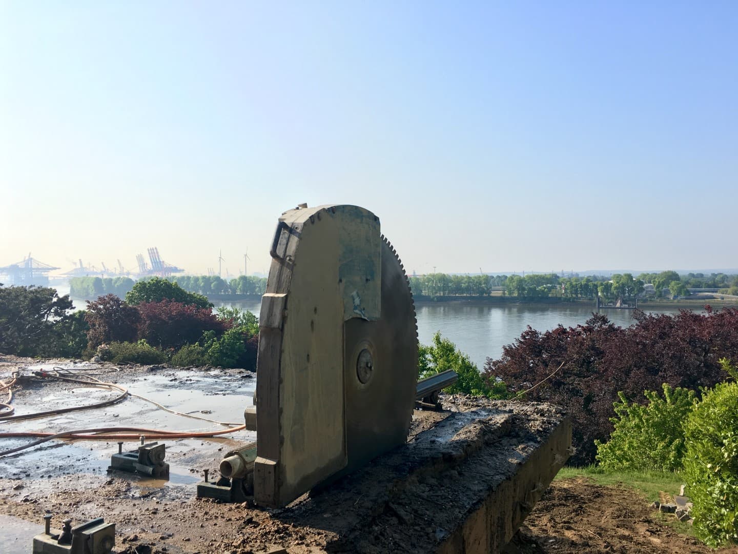 Großes Sägeblatt im Vordergrund mit dem Hamburger Hafen im Morgenlicht